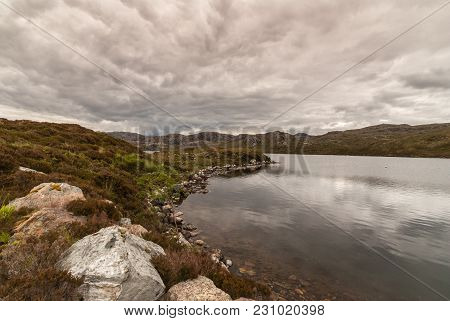 Loch Tollaidh, Scotland - June 9, 2012: Heavy Dark Brown Cloudscape Over Lake Colors Water Dark. Set