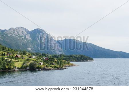 View of Jondal Commune and Hardangerfjord Fjord, Norway. Summer landscape with a Scandinavian village. Sunny weather