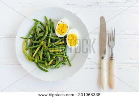 Cooked Green Beans With Boiled Eggs In White Plate. Healthy Vegetarian Food Concept. Top View.