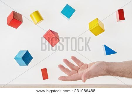 Male Hand Juggling Colorful Wooden Shapes. Concept Of Creative, Logical Thinking. Floating Shapes.