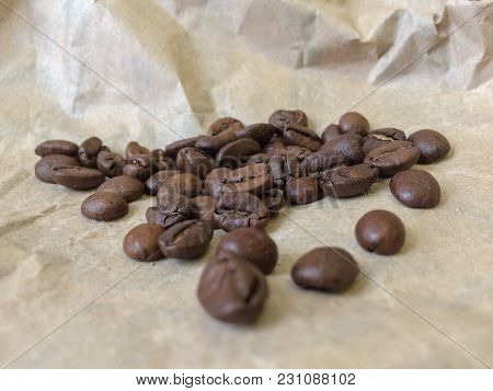 Coffee Beans On Paper Background. Closeup Photo