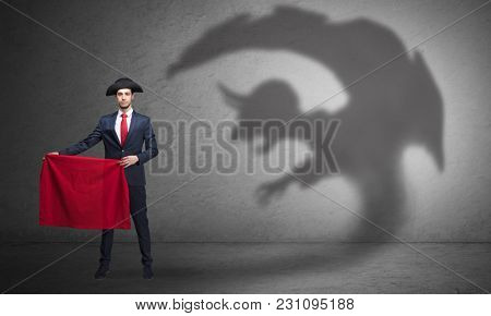 Businessman standing with red cloth in his hand and imp shadow on the background