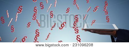 Businessman holding digital tablet against abstract blue background