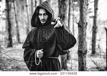 The Black Monk Pointing His Finger In The Woods