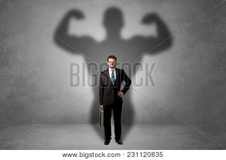 Lovely serious businessman standing with a muscular powerful shadow behind his back