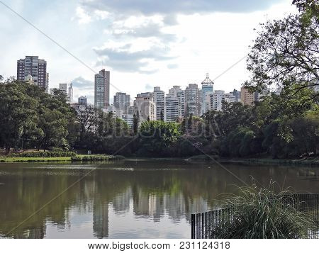 View Of The Aclimacao Park With The Lake And Vegetation At The Front And The Buildings In The Backgr
