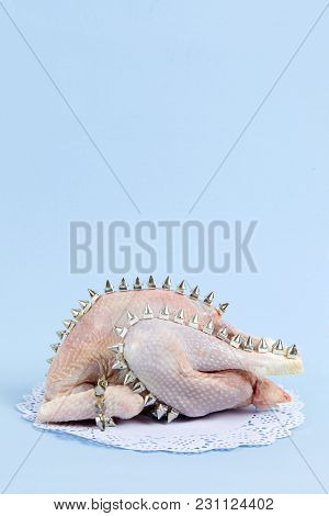 Playful Mashup Using A Chicken And Punk Spikes On A Blue Background. Minimal Color Still Life And Qu