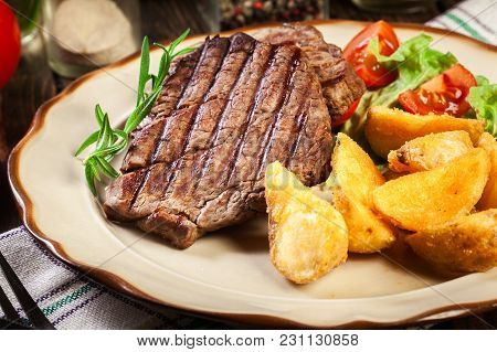 Succulent Portions Of Grilled Fillet Mignon Served With Baked Potatoes