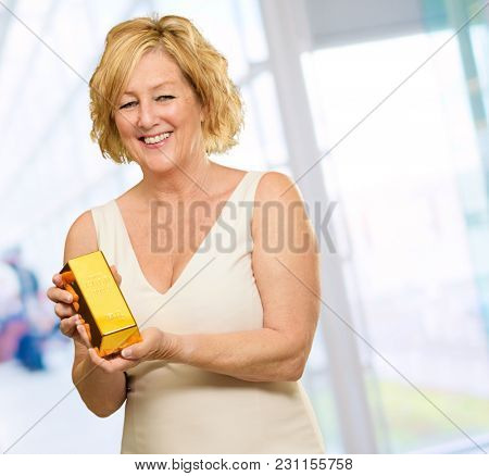 Happy Woman Holding Goldbar, Indoors
