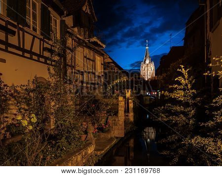 Church St. Peter Et Paul In Wissembourg, France On A Cloudy Night, Blue Sky, Canal