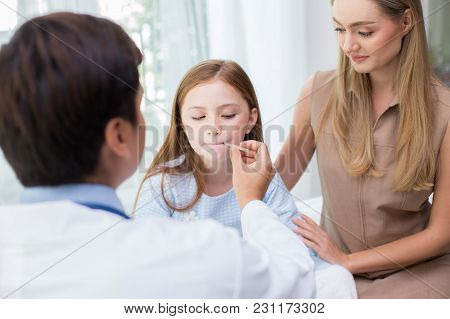 Male Doctor Examining Inside Girl Mouth In Clinic. People With Health Care And Medical Concept