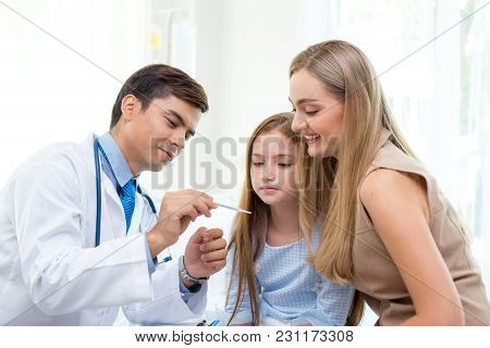 Male Doctor Examining Girl In Clinic. People With Health Care And Medical Concept