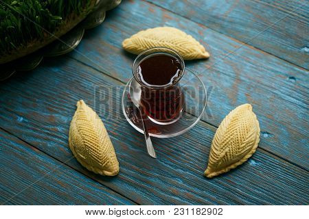 Traditional Azerbaijan Sweet Pastry Shekerbura With Nuts And Honey And Glass Of Black Tea On Wooden 