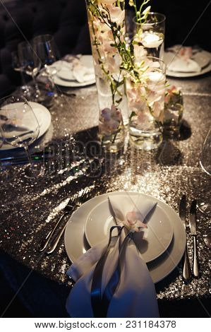Lighted White Candles Stand Around Luxury Pink Rose Bouquet On A Table