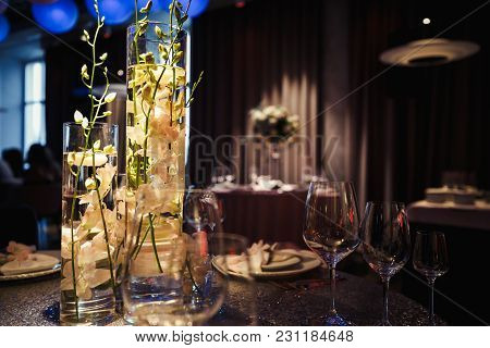 Lighted White Candles Stand Around Luxury Pink Rose Bouquet On A Table