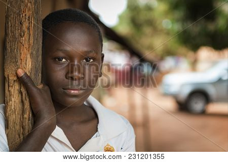 Nhacra, Republic Of Guinea-bissau - January 28, 2018: Portrait Of A Young Boy At The Entrance Of His