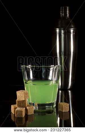 A Glass With Absinth On A Black Reflecting Surface