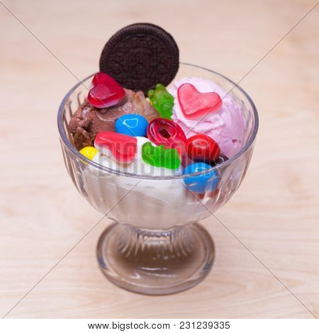 Pink ice cream croissant with biscuits and sweets