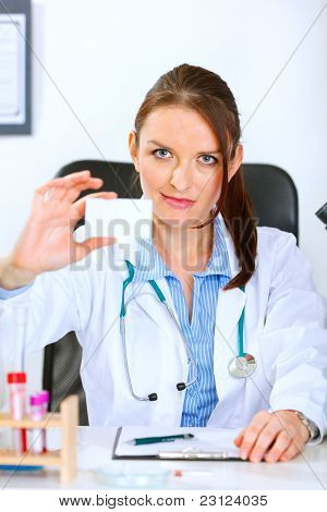 Autoridad médico mujer sentada en la mesa de la oficina y con tarjetas en blanco