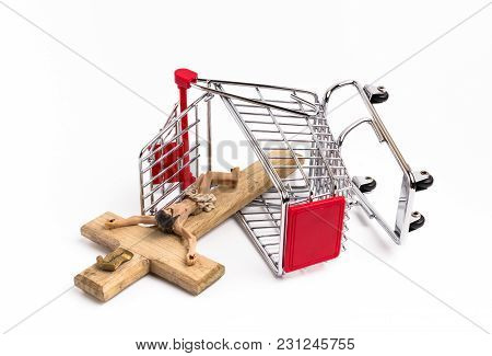 Shopping Cart Overturned With Crucifix On The Ground. Conceptual Representation Of Commodification O