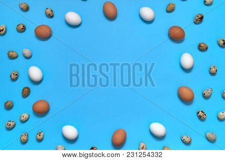 Frame Of White, Brown And Quial Eggs On Blue Background, Copy Space. Healthy Food Concept. Top View,