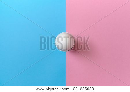 White Egg Standing On Egg Cup On Blue And Pink Pastel Background, Copy Space. Boiled Egg In Stand On