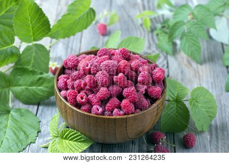Fresh Organic Ripe Raspberry With Leaf In Bowl On Wooden Table, Selective Focus