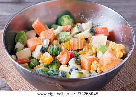 Frozen Vegetables In Bowl On Wooden Table Background. Mixed Vegetables In A Bowl