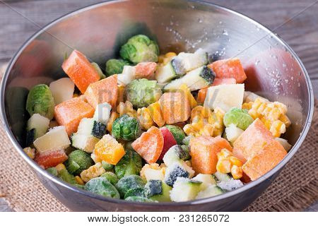Frozen Vegetables In Bowl On Wooden Table Background. Mixed Vegetables In A Bowl