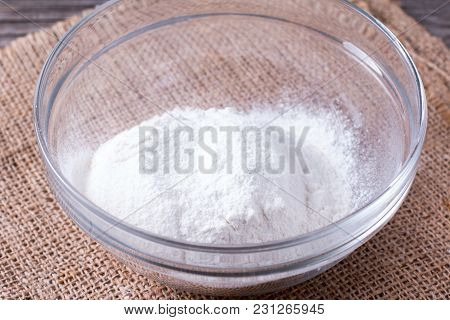 Flour In Glass Bowl On The Wooden Table Closeup