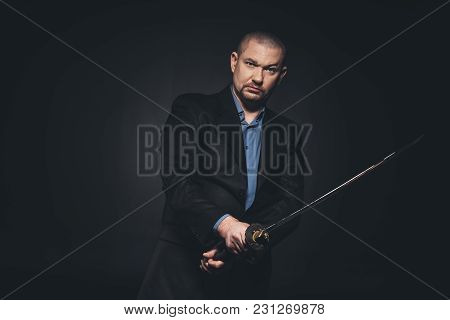 Serious Man In Suit With Katana On Black