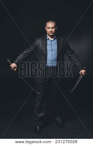 Handsome Serious Man In Suit With Dual Katana Swords On Black