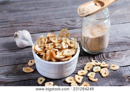 Spoon With Granulated Dried Garlic On Old Wooden Background