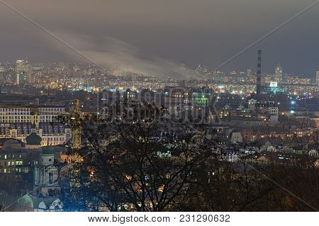 View Of The Ancient Podil District, Factory With Chemneys And Modern Obolon District At Background. 
