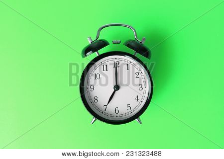 Vintage Black Alarm Clock On Green Color Background