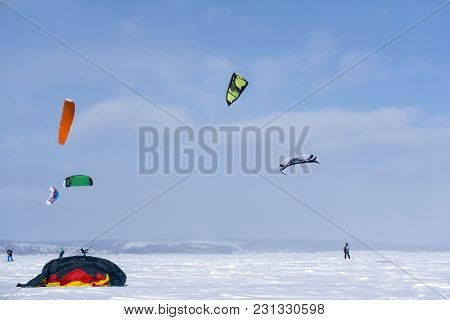 Perm, Russia - March 09, 2018: Snowkiters Train On The Ice Of A Frozen Lake In The Background Of A W