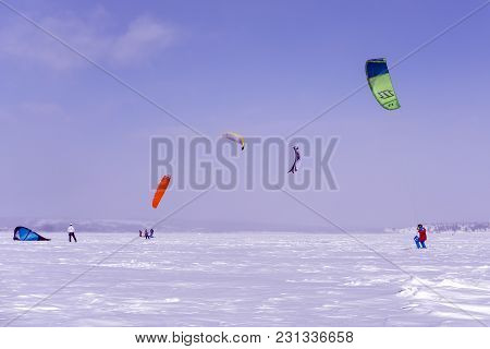 Perm, Russia - March 09, 2018: Snowkiters Train On The Ice Of A Frozen Lake In The Background Of A W
