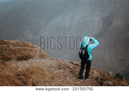 Man In High Altitude Rocky Mountain Landscape In Front Of A Deep Ravine. Trekking Trail On Santo Ant