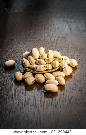 Close Up Of Ayurvedic Herb Kuanch,cowhage,mucuna Pruriens With Powder On A Brown Wooden Surface In D