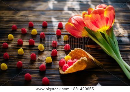 Blossoming Red Tulips On A Wooden Background With Sweets