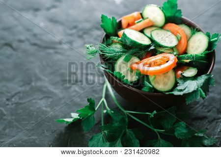 Fresh Salad With Vegetables On A Black Matte Background. The Concept Of A Healthy Diet.