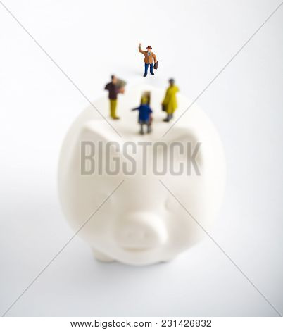 Businessman Figurines On A Piggybank. Money, Business, Corruption And Expectation Concept.