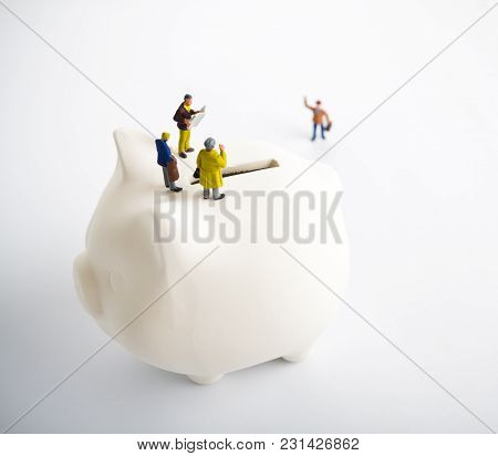 Businessman Figurines On A Piggybank. Money, Business, Corruption And Expectation Concept.