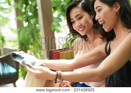 Happy Young Asian Women Found Great Clothes On Sale