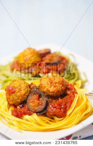 Two-colour Green And Yellow Italian Coocked Pasta With Meatballs, Tomatoes And Eggplant. Close-up Ph
