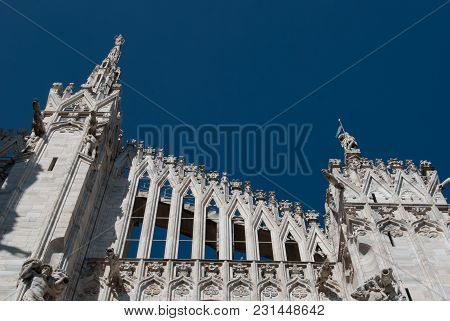 Some Spiers Surmounted By Statues Of The Milan Cathedral With A Clear And Blue Sky