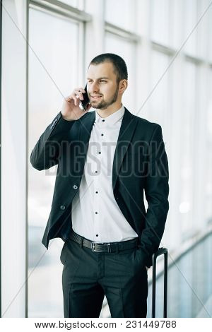 Businessman Speak On Phone Near Baggage While Waiting For Flight In Airport