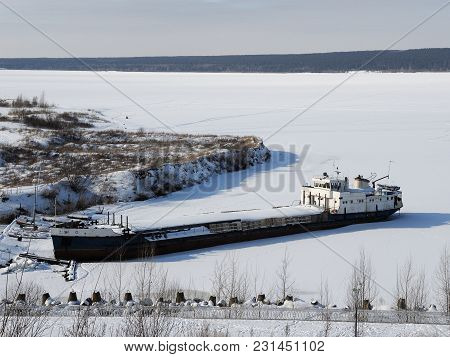 River Dry Cargo Ship In The Winter Parking In The Bay Of The Frozen River