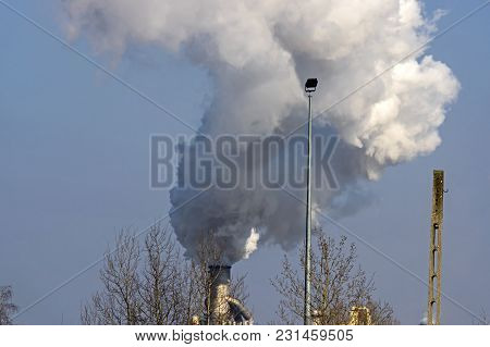 A Vast, Flat Area. In The Distance You Can See A Factory, A Shiny Metal Structure .. From The Chimne