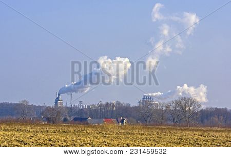 A Vast, Flat Area. In The Distance You Can See A Factory, A Shiny Metal Structure .. From The Chimne